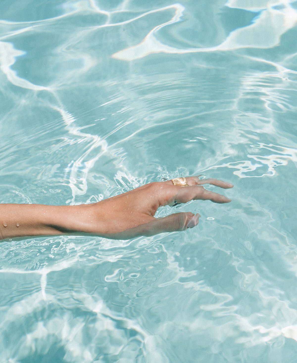 Woman's hand in pool water